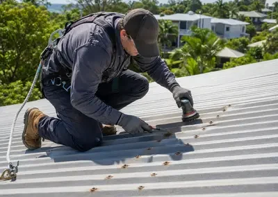 Roofer treating rust and corrosion on a metal roof