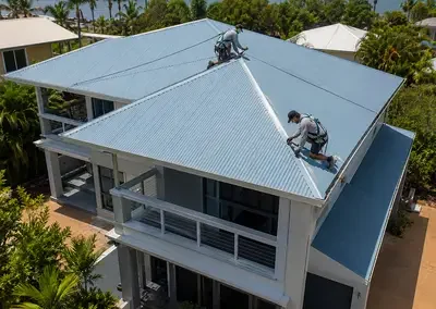 Roofer treating rust and corrosion on a metal roof
