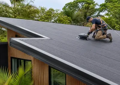 Metal roof being recoated as part of a roof restoration in Darwin